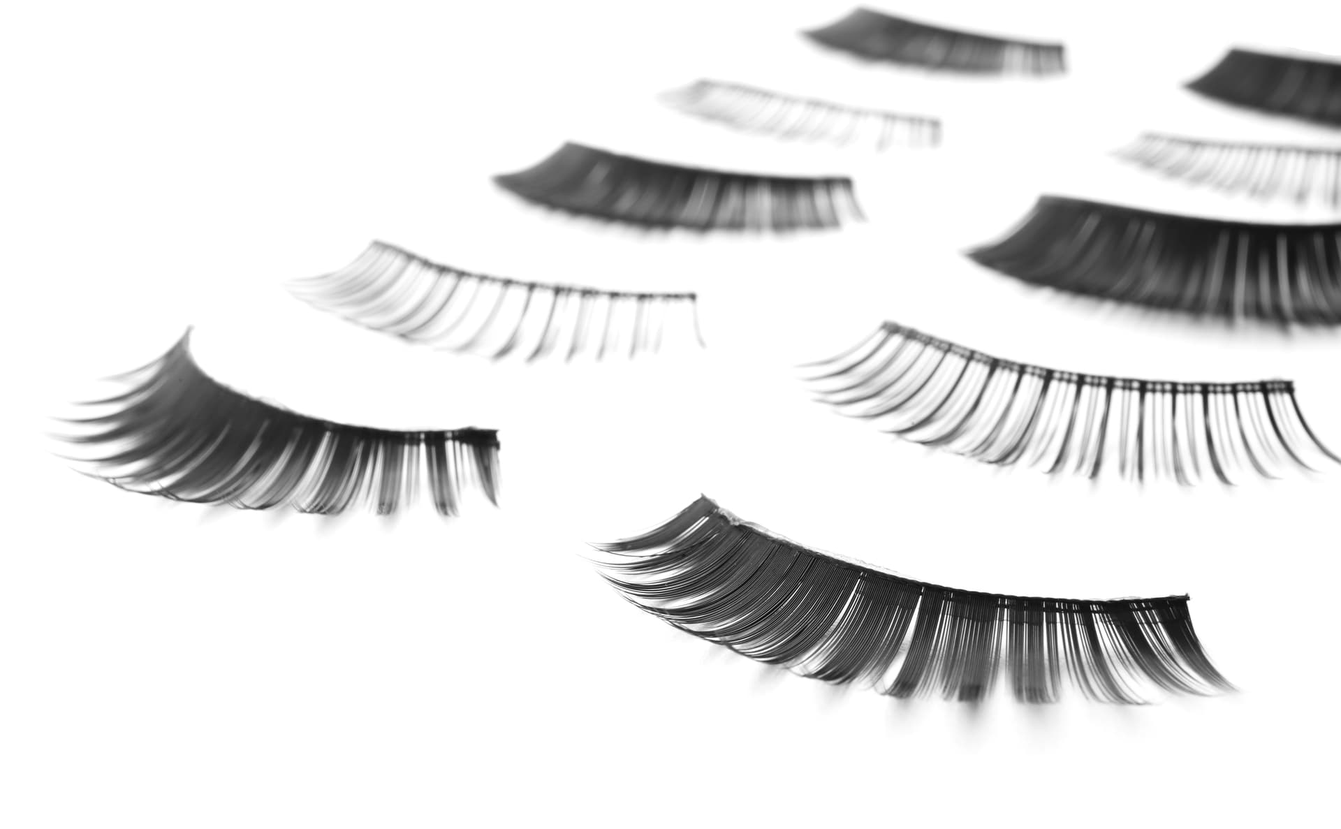 Several pairs of lash extensions laid out against a plain white background